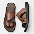 Brown sandals with black soles on a light gray background