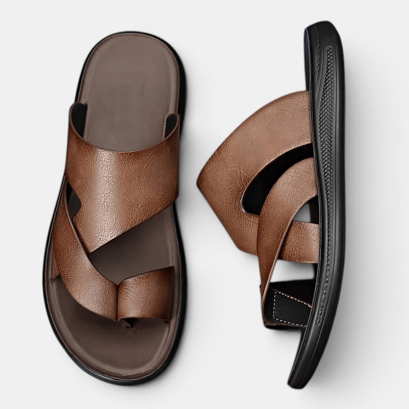 Brown sandals with black soles on a light gray background