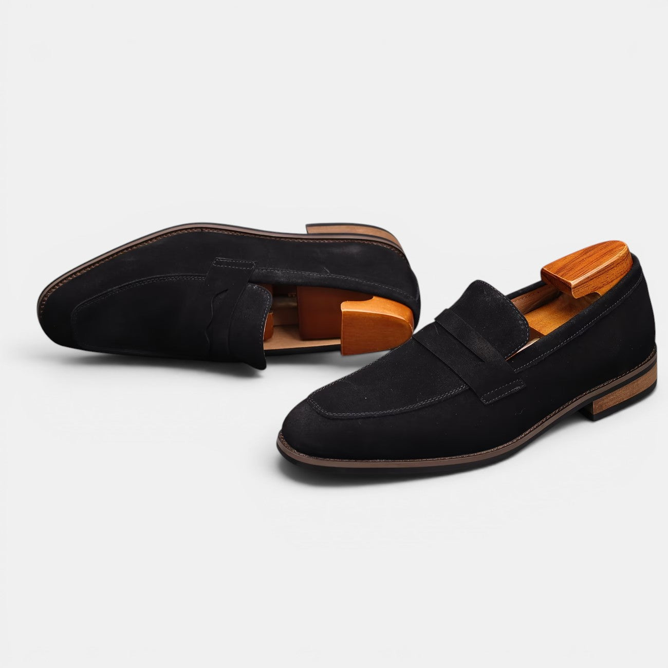 Black loafers with wooden soles on a light gray background