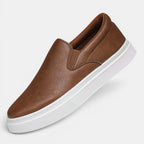 Brown slip-on sneaker with white sole on a light gray background