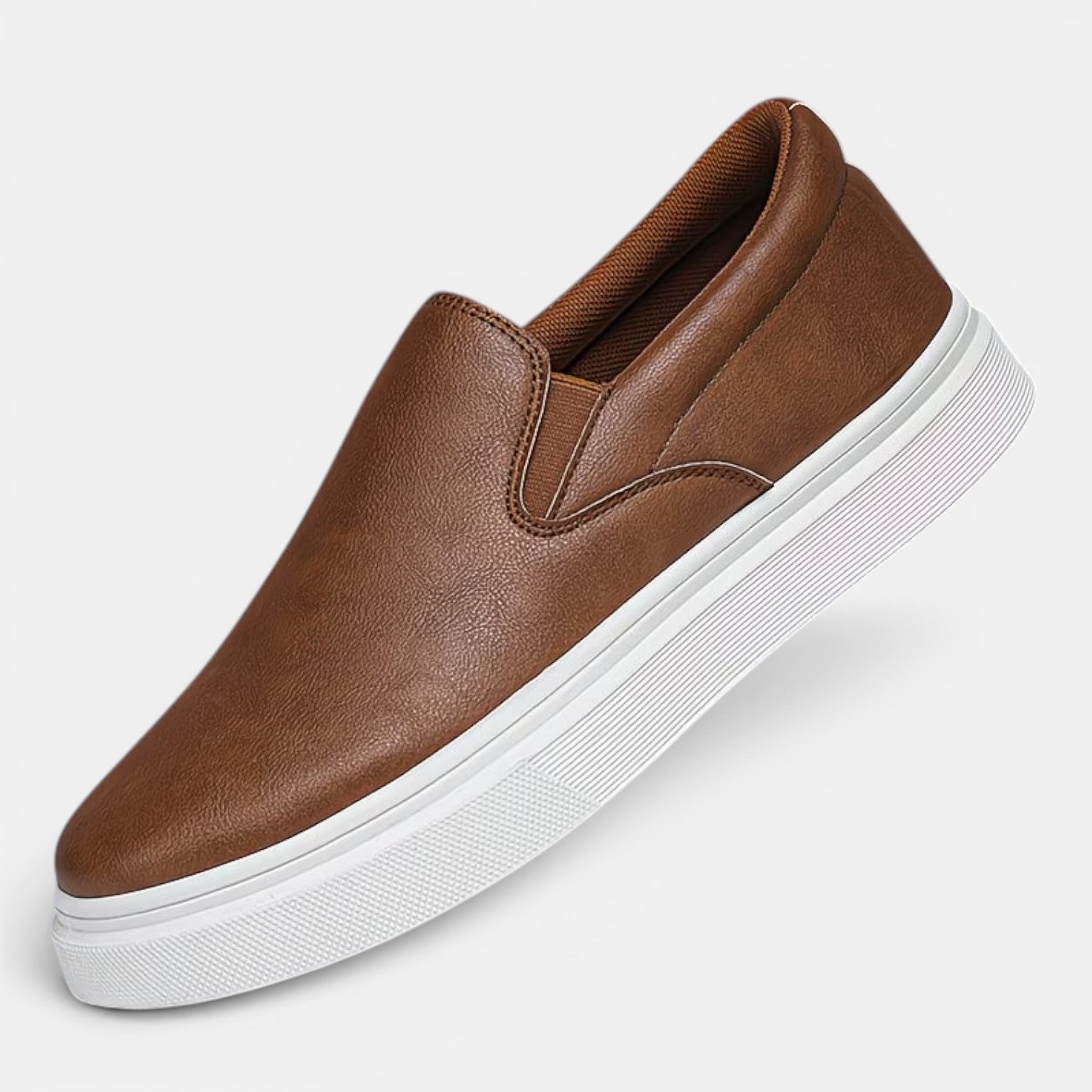 Brown slip-on sneaker with white sole on a light gray background