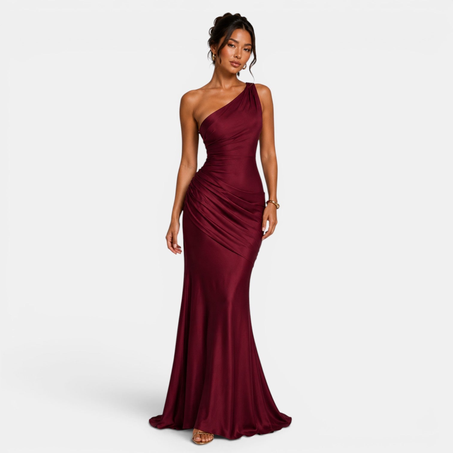 Woman wearing a burgundy one-shoulder gown on a white background