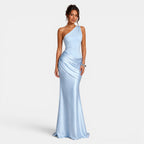 Woman wearing a light blue one-shoulder gown on a plain background