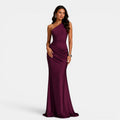 Woman wearing a one-shoulder burgundy gown on a white background