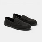 Pair of black loafers on a light gray background