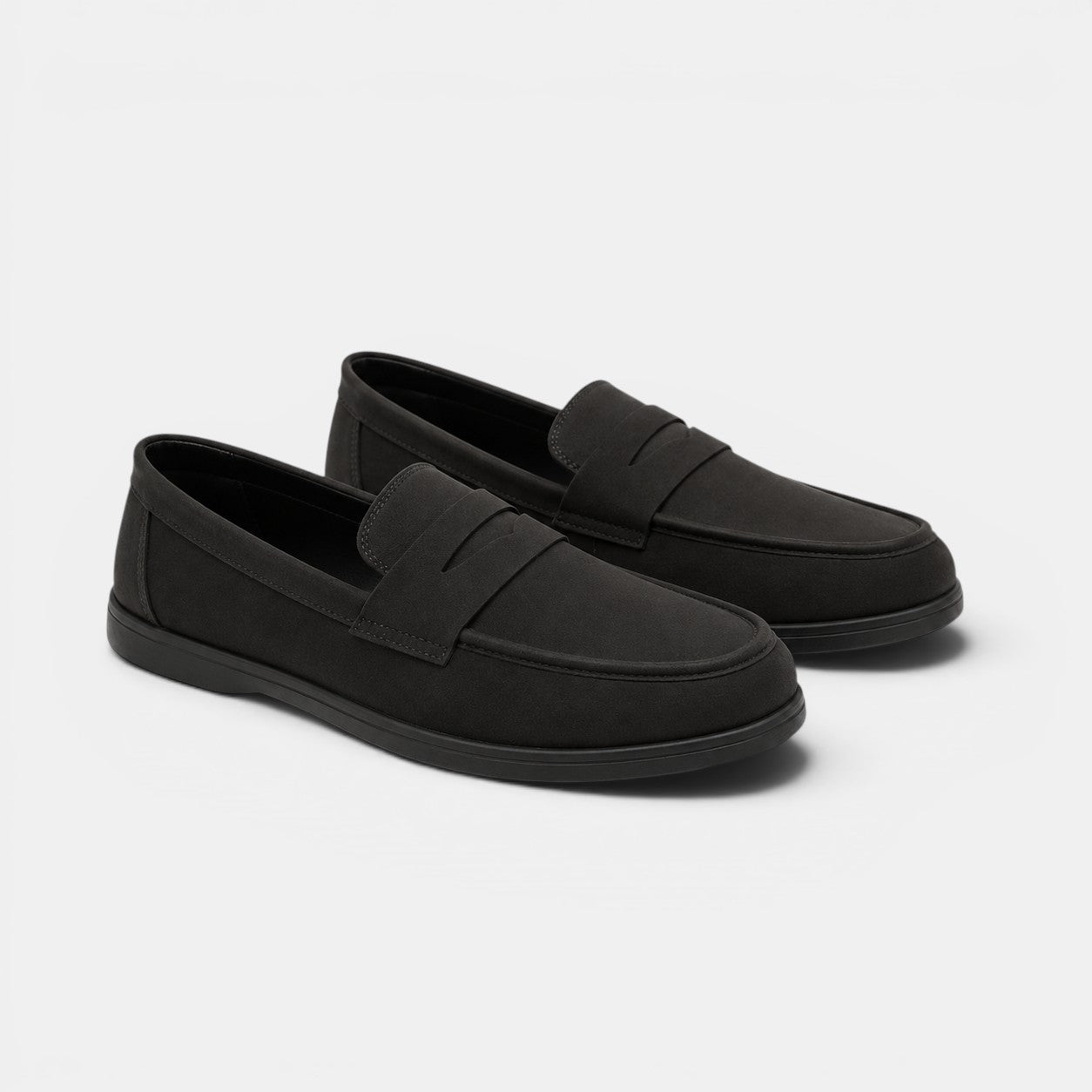 Pair of black loafers on a light gray background