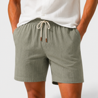 Person wearing green shorts with a white background