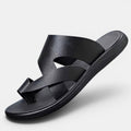 Black sandal with criss-cross straps on a light gray background
