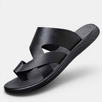 Black sandal with criss-cross straps on a light gray background