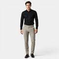 Man wearing a black shirt and beige pants on a white background