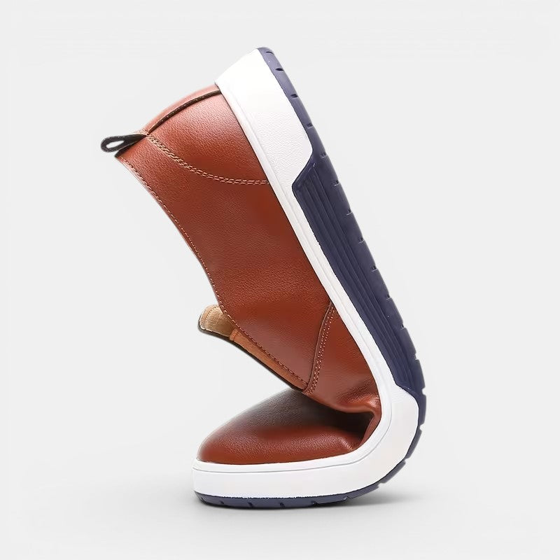 Brown leather shoe with white sole on a light gray background