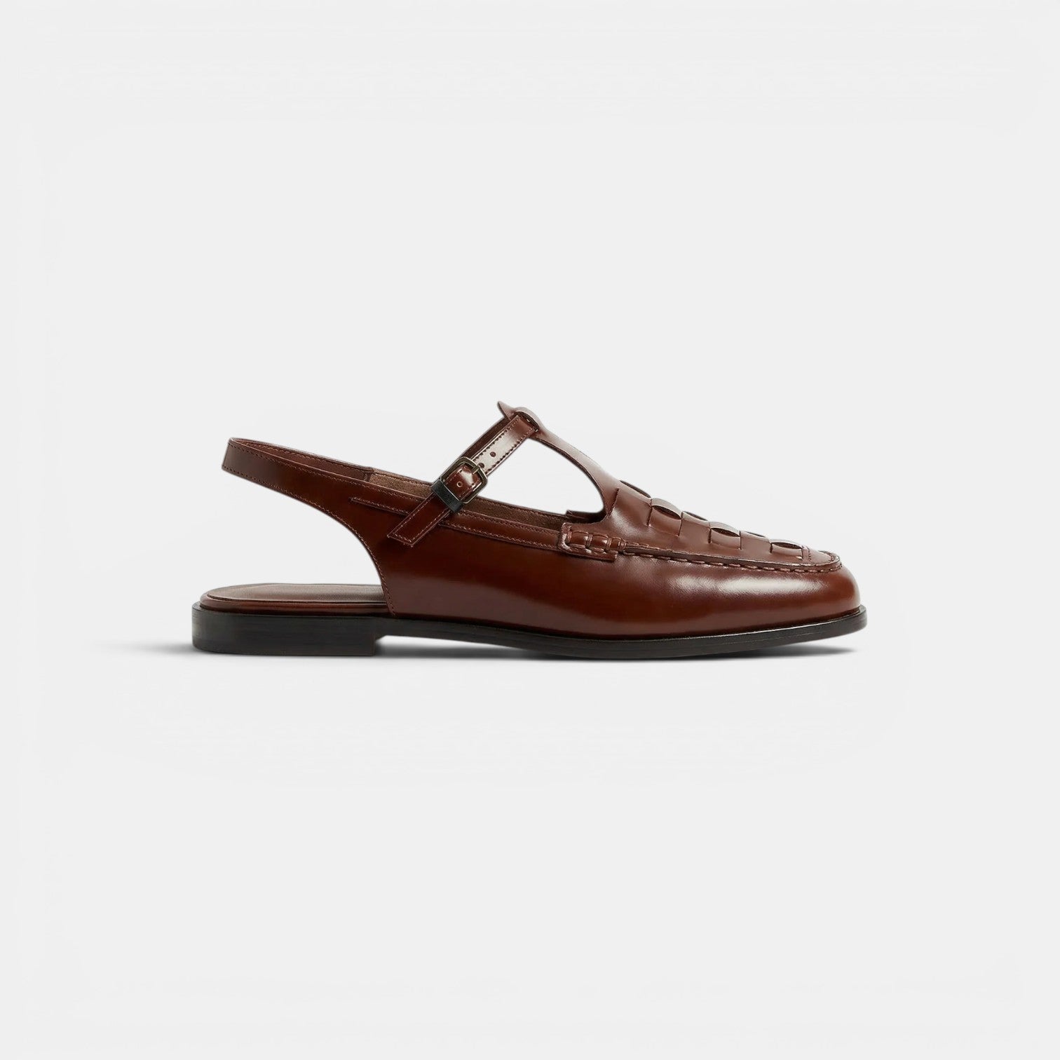 Black leather shoe with orange shoelace on a white background