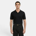 Man wearing a black polo shirt and black pants on a white background