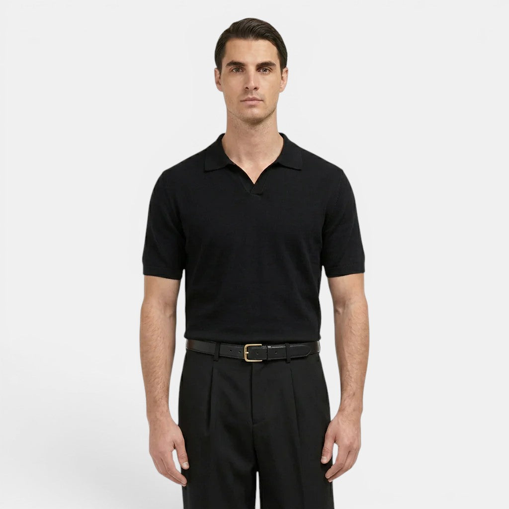 Man wearing a black polo shirt and black pants on a white background
