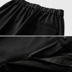 Close-up of black pants with elastic waistband and pleated design.