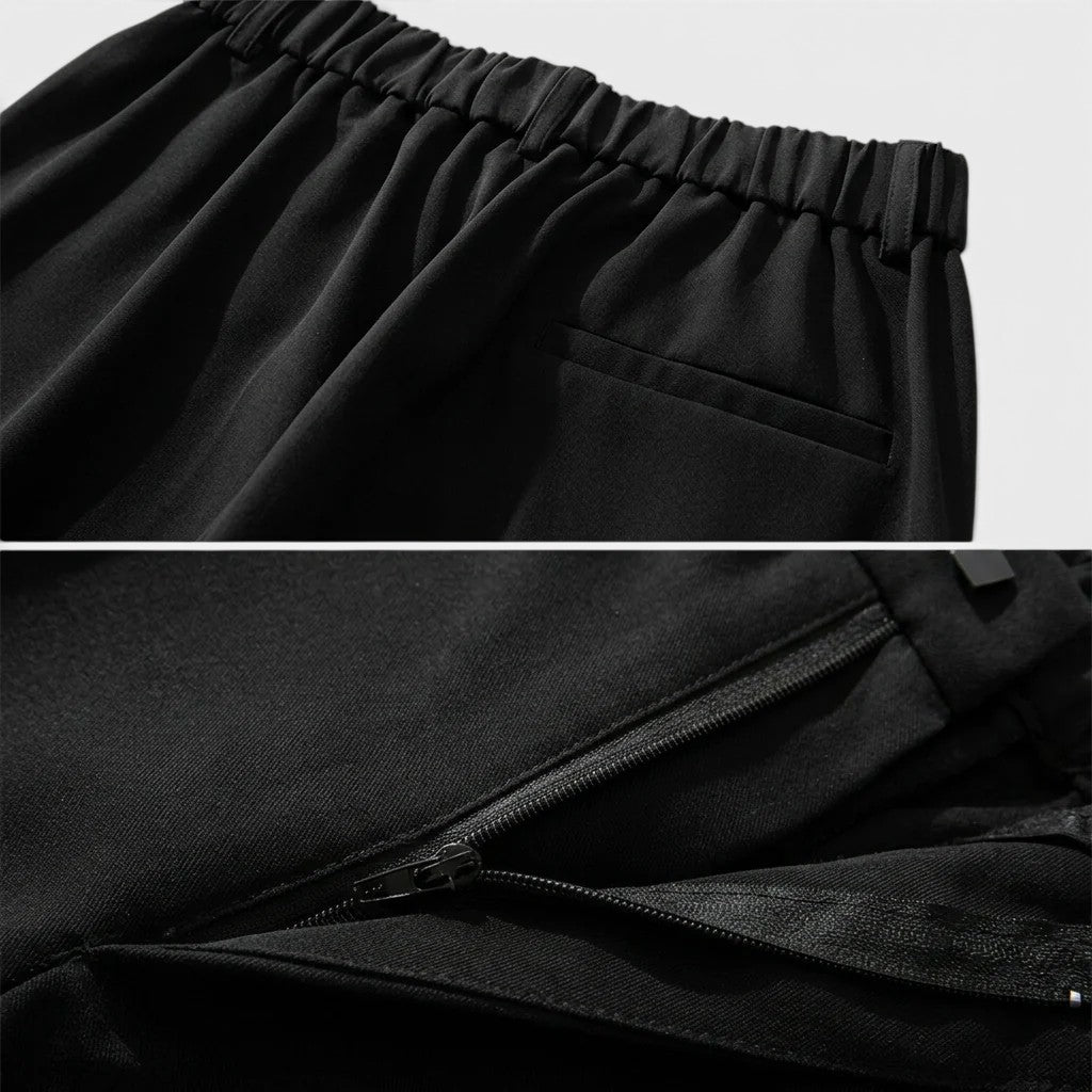 Close-up of black pants with elastic waistband and pleated design.