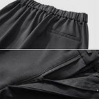 Close-up of black pants with an elastic waistband and zipper detail.