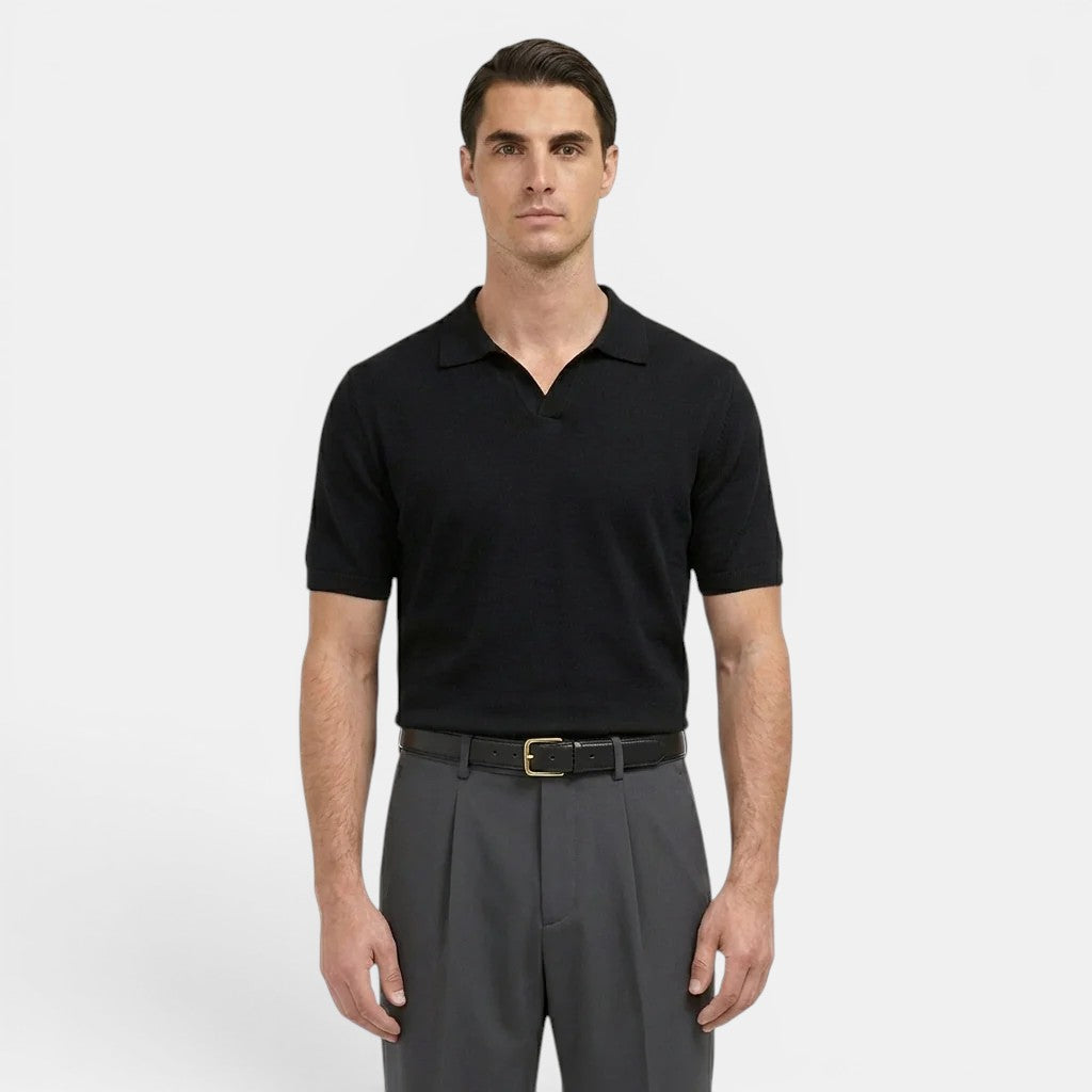 Man wearing a black polo shirt and gray pants on a white background