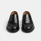 Pair of black loafers on a light gray background