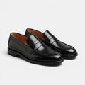 Pair of black loafers on a light gray background