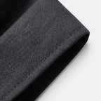 Close-up of charcoal gray suit fabric showcasing fine texture and tailored stitching detail.