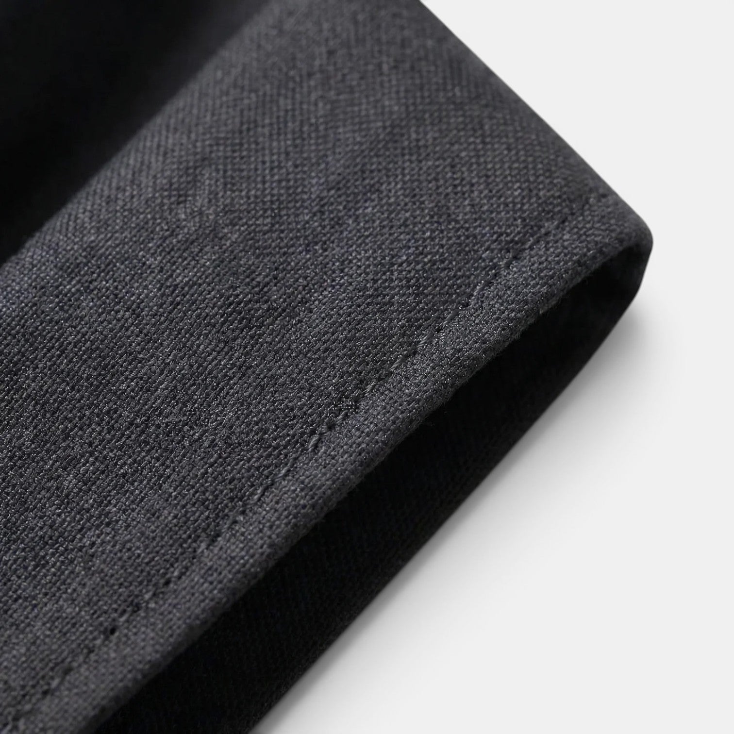 Close-up of charcoal gray suit fabric showcasing fine texture and tailored stitching detail.