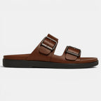 Brown sandal with double buckles on a light gray background