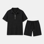 Black zip-collar polo shirt and matching drawstring shorts set displayed against a light gray background.