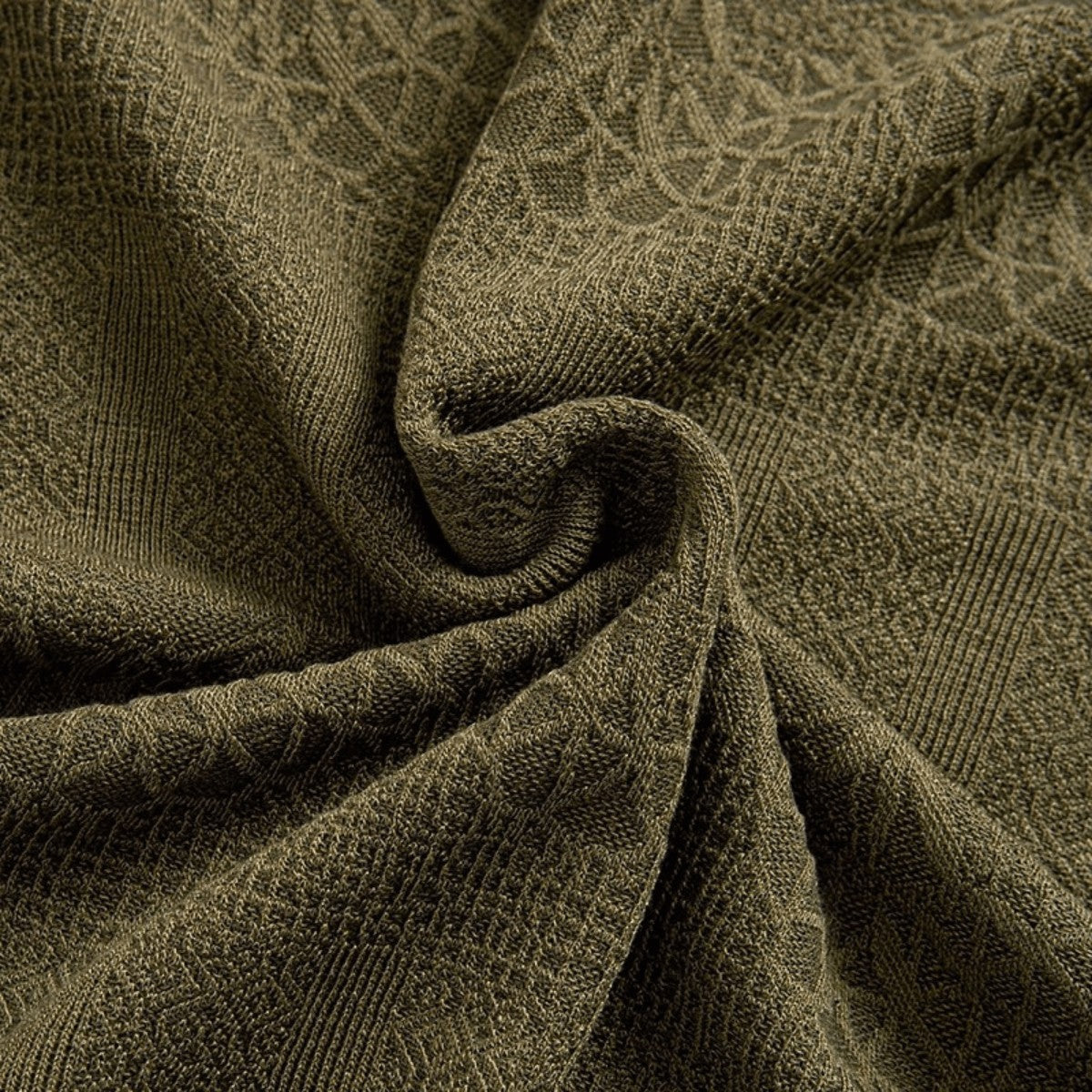 Close-up of olive green textured knit fabric, highlighting the intricate woven pattern and soft drape.