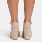 Beige wedge sandals on a white background