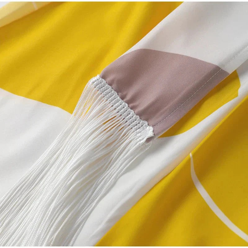 Close-up of a white fabric with fringes on a yellow background