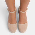Beige high-heeled shoes with ankle straps on a white background