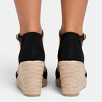 Black wedge sandals with beige soles on a white background