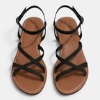 Pair of brown sandals with black straps on a light gray background