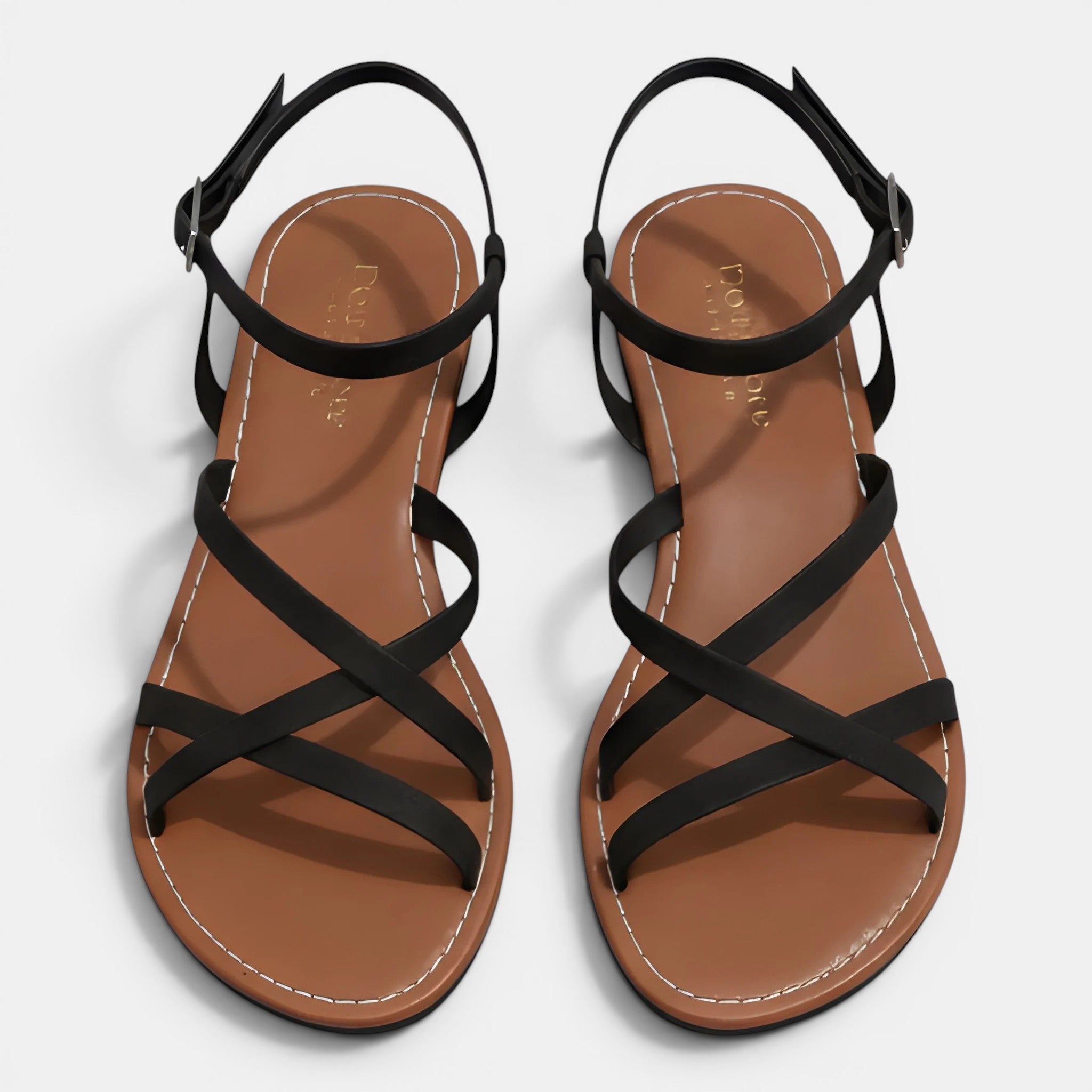 Pair of brown sandals with black straps on a light gray background