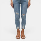 Light blue distressed jeans worn by a person on a white background