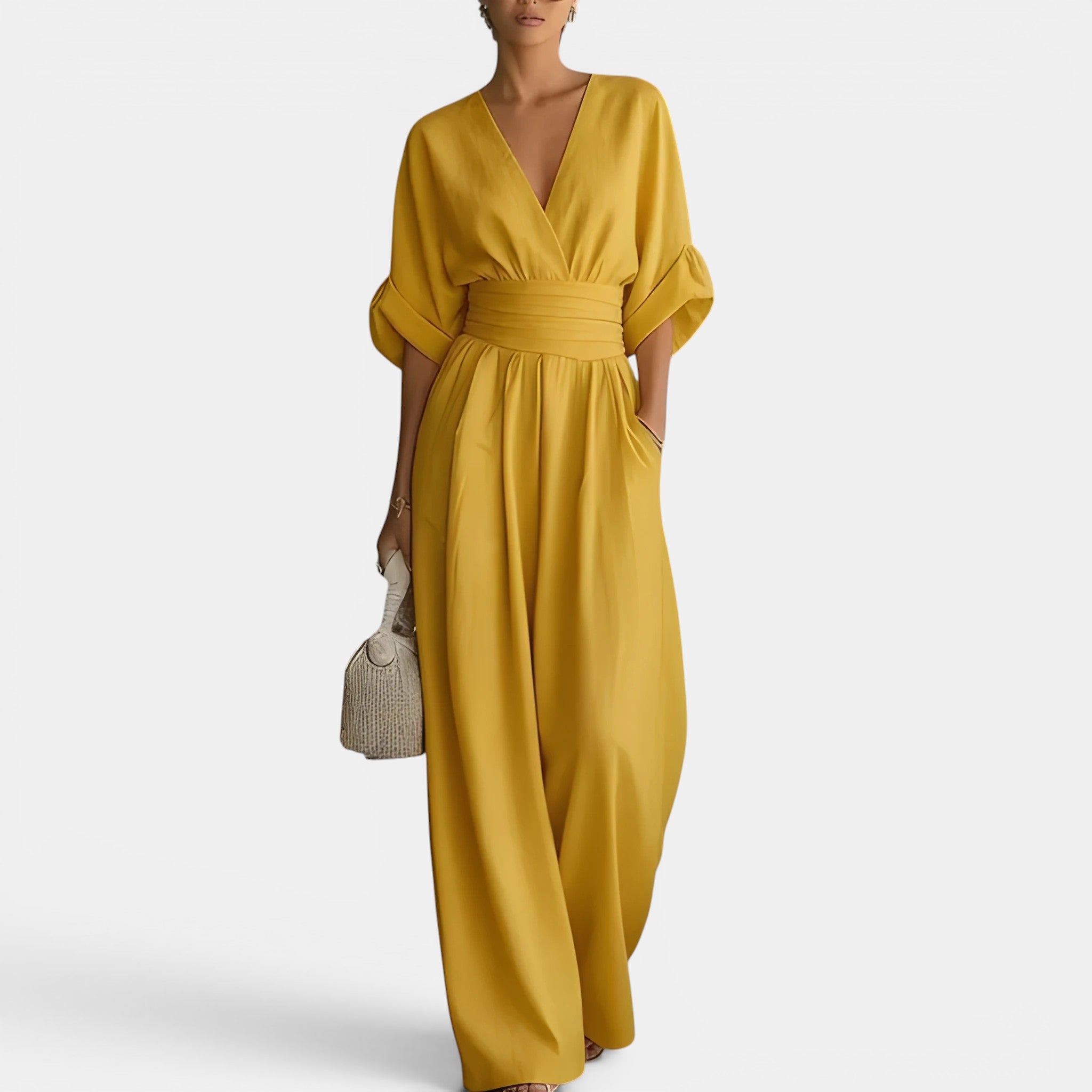Woman wearing a mustard yellow dress holding a small bag on a white background